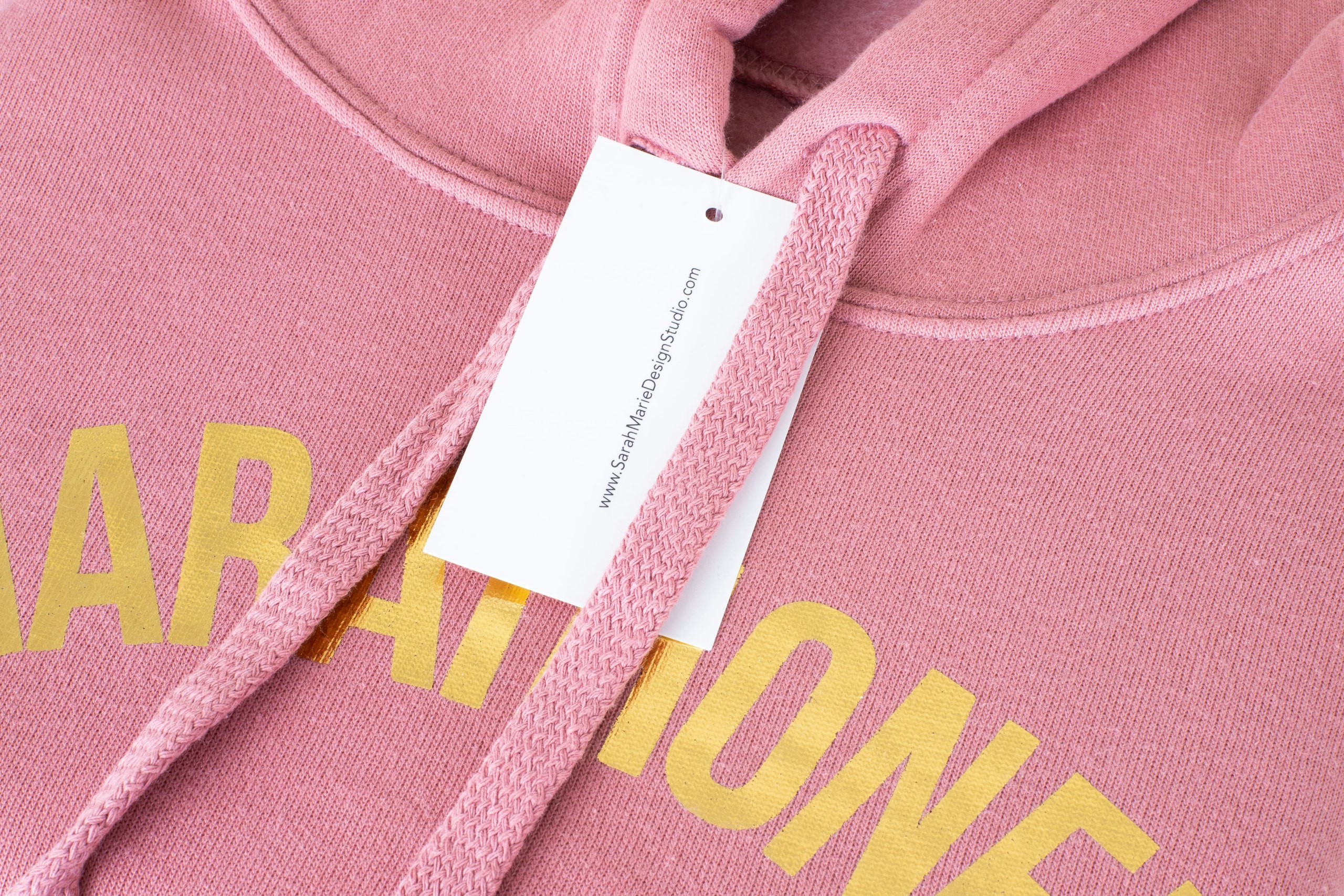 A custom hang tag on a pink sweatshirt with foil ink