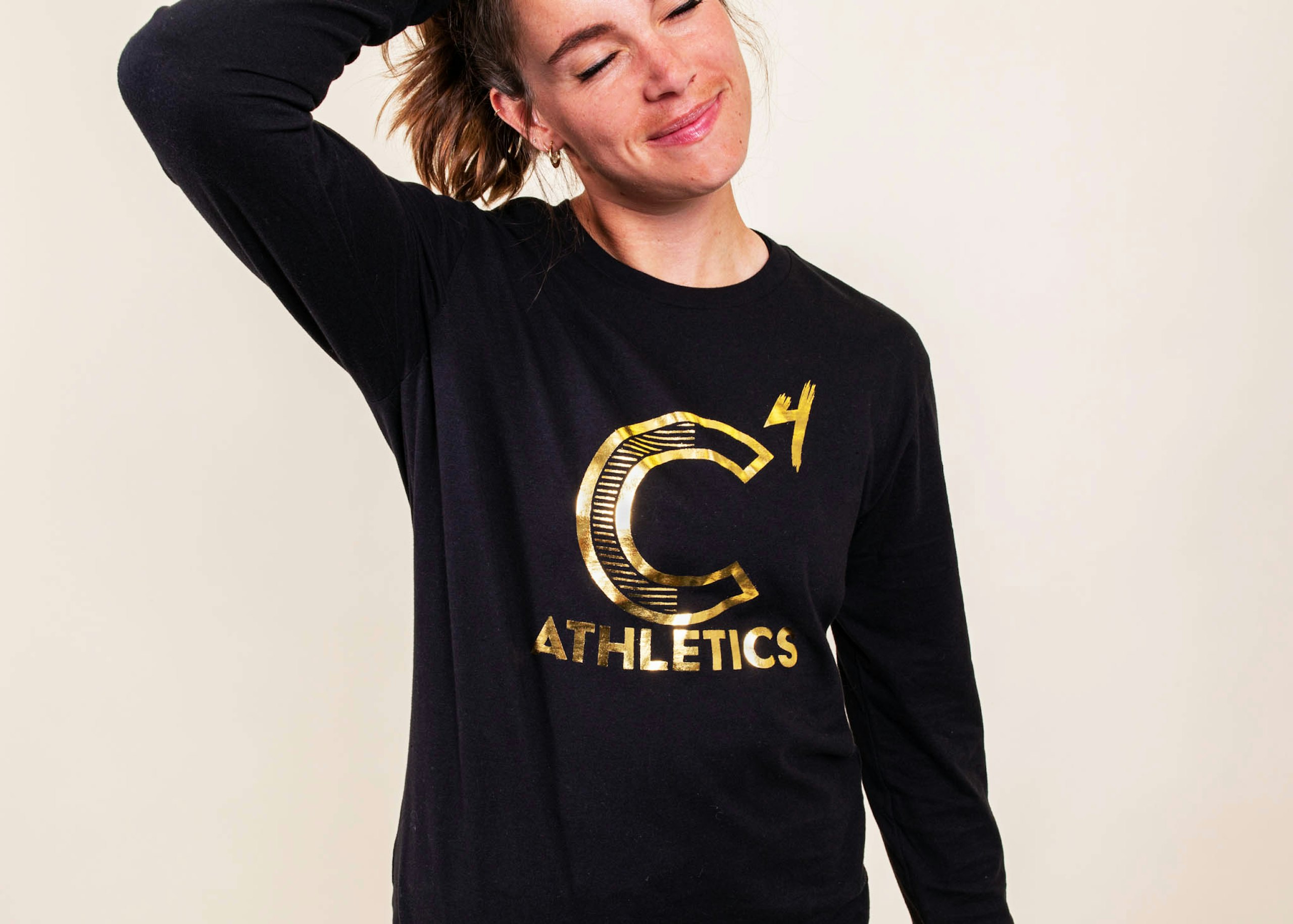 a girl wears a black sweatshirt with a gold foil design