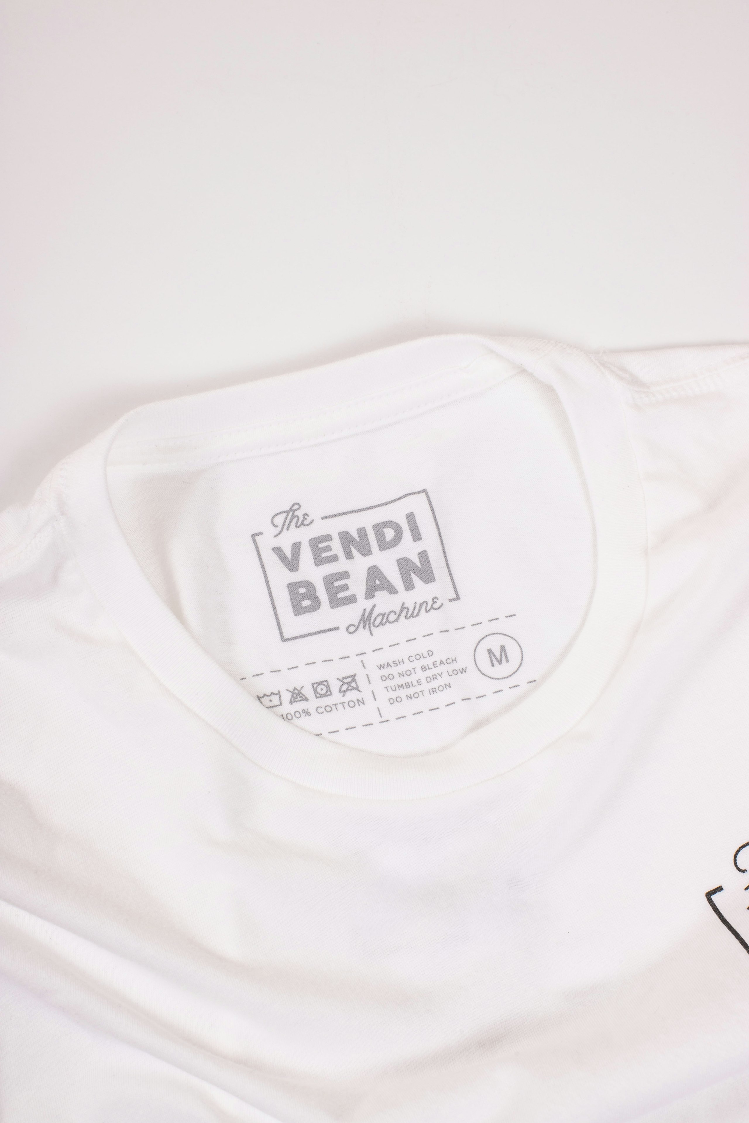 A custom printed tag for the Vendi Bean Machine on a white shirt