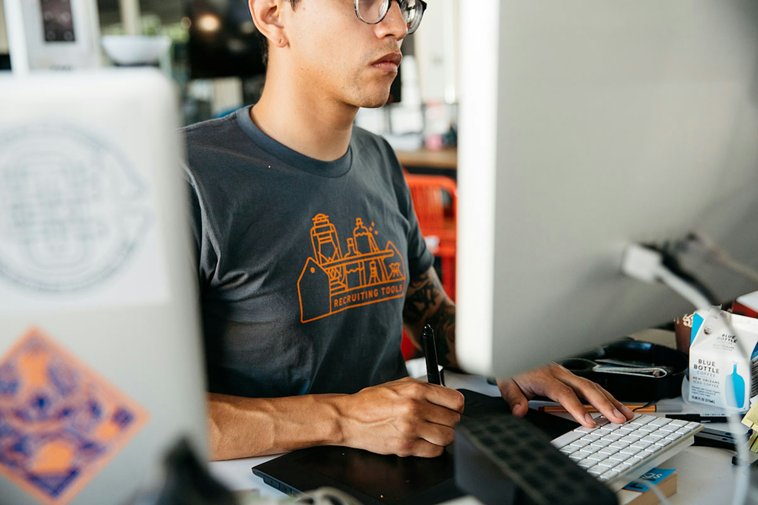 Someone working for a remote job, while wearing a custom t-shirt that says "recruiting tools"