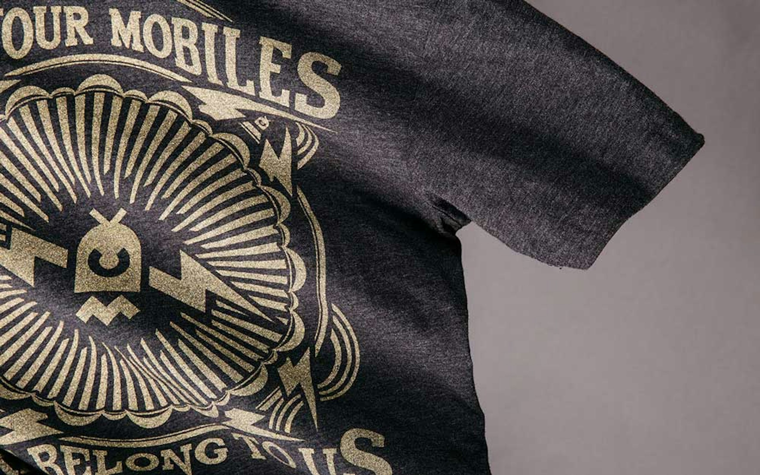 A black heathered shirt with a gold metallic design