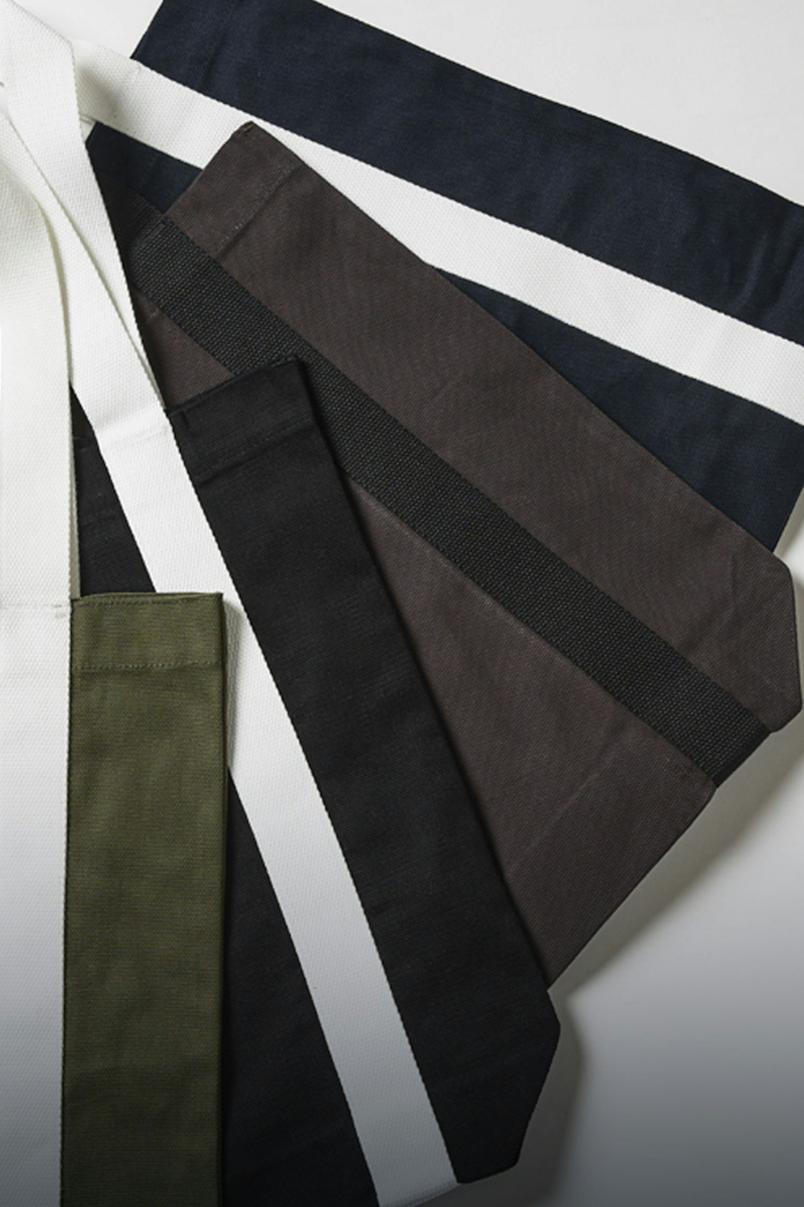 Tote bags lying flat in a fan on top of each other