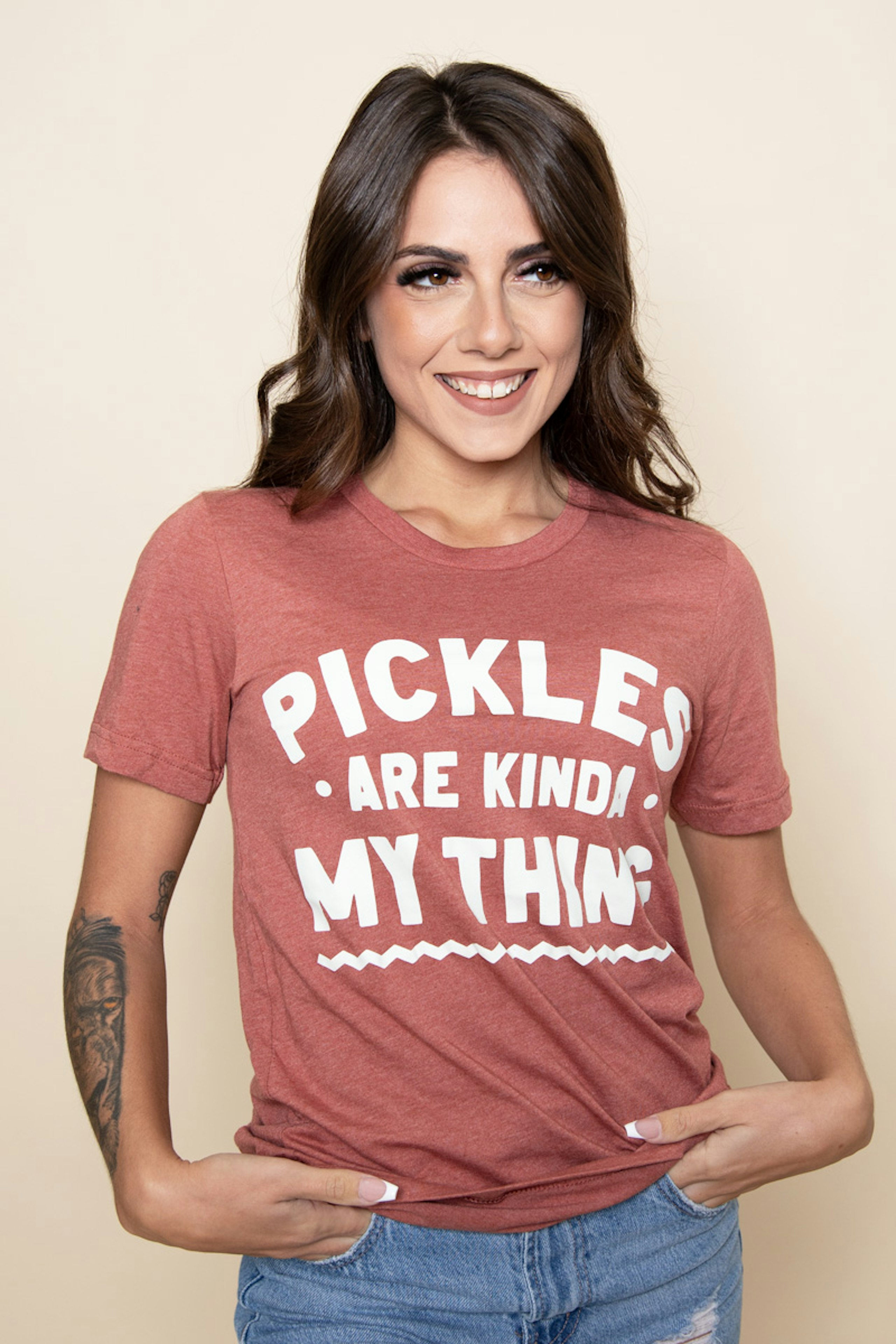 women wearing a dusty pink t-shirt with white words, pickles are kind of my think, printed on the front