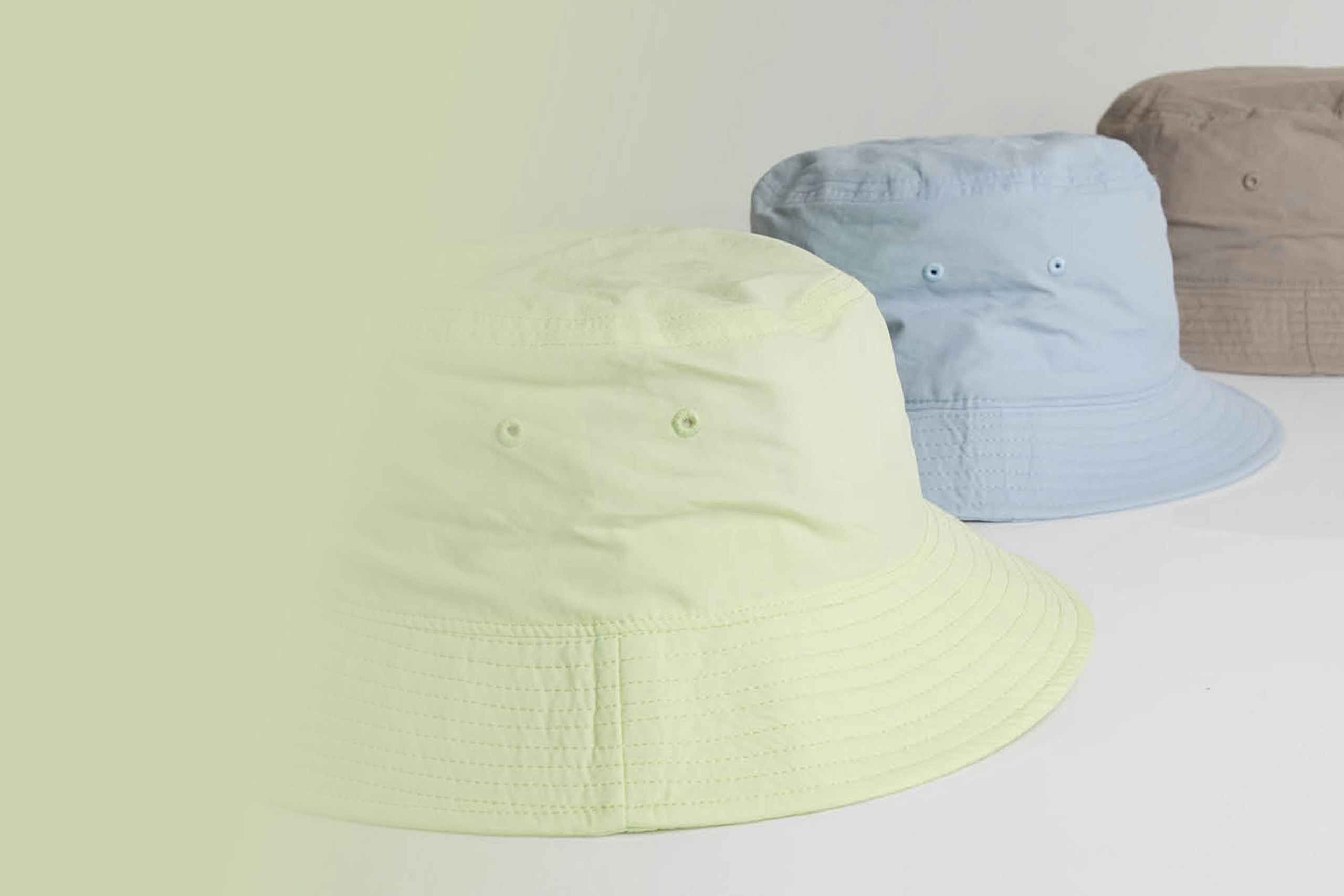 three bucket hats, yellow-green, light blue, brown