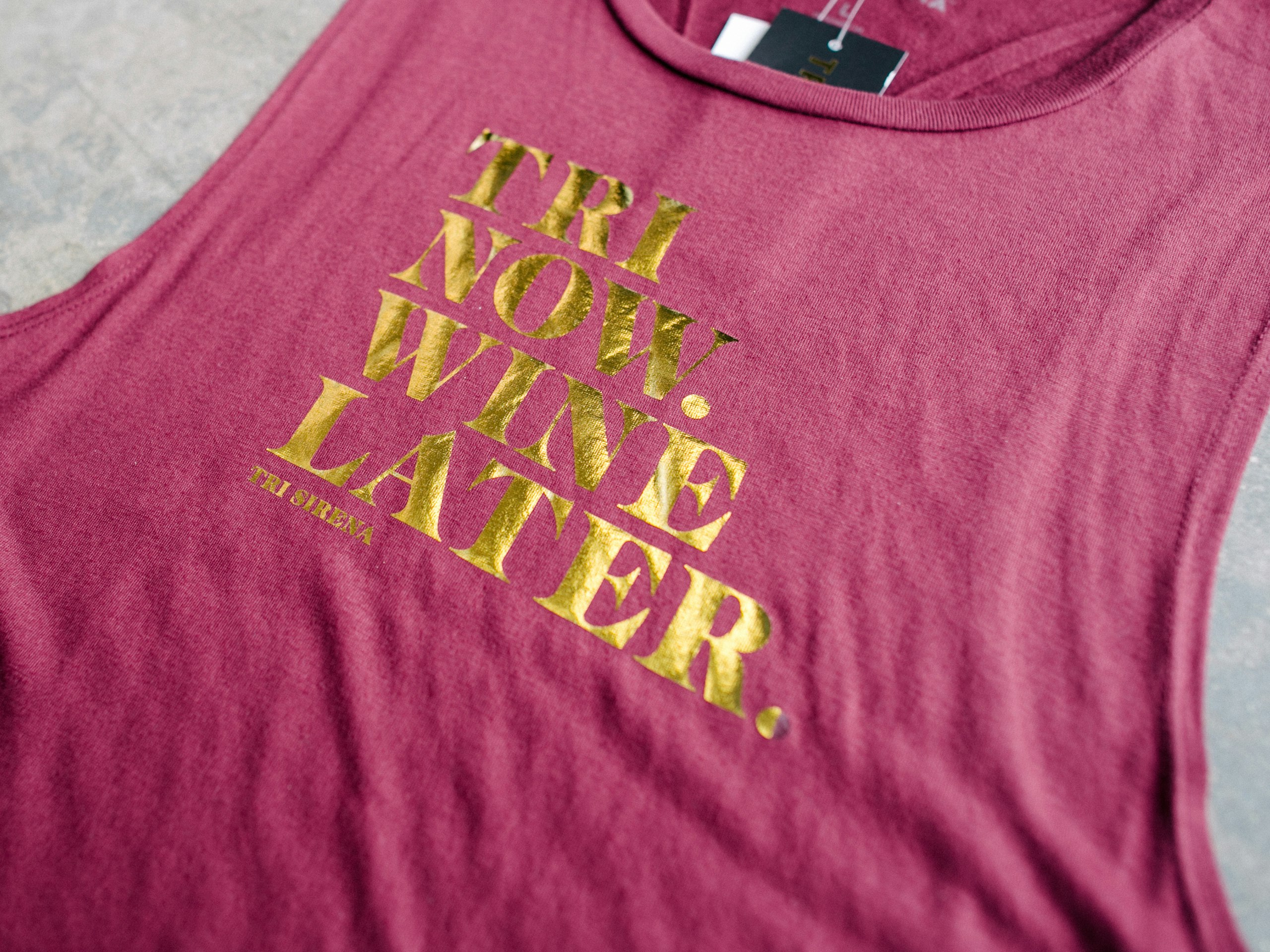 Red tank top with gold foil printing saying "Tri Now. Wine Later."