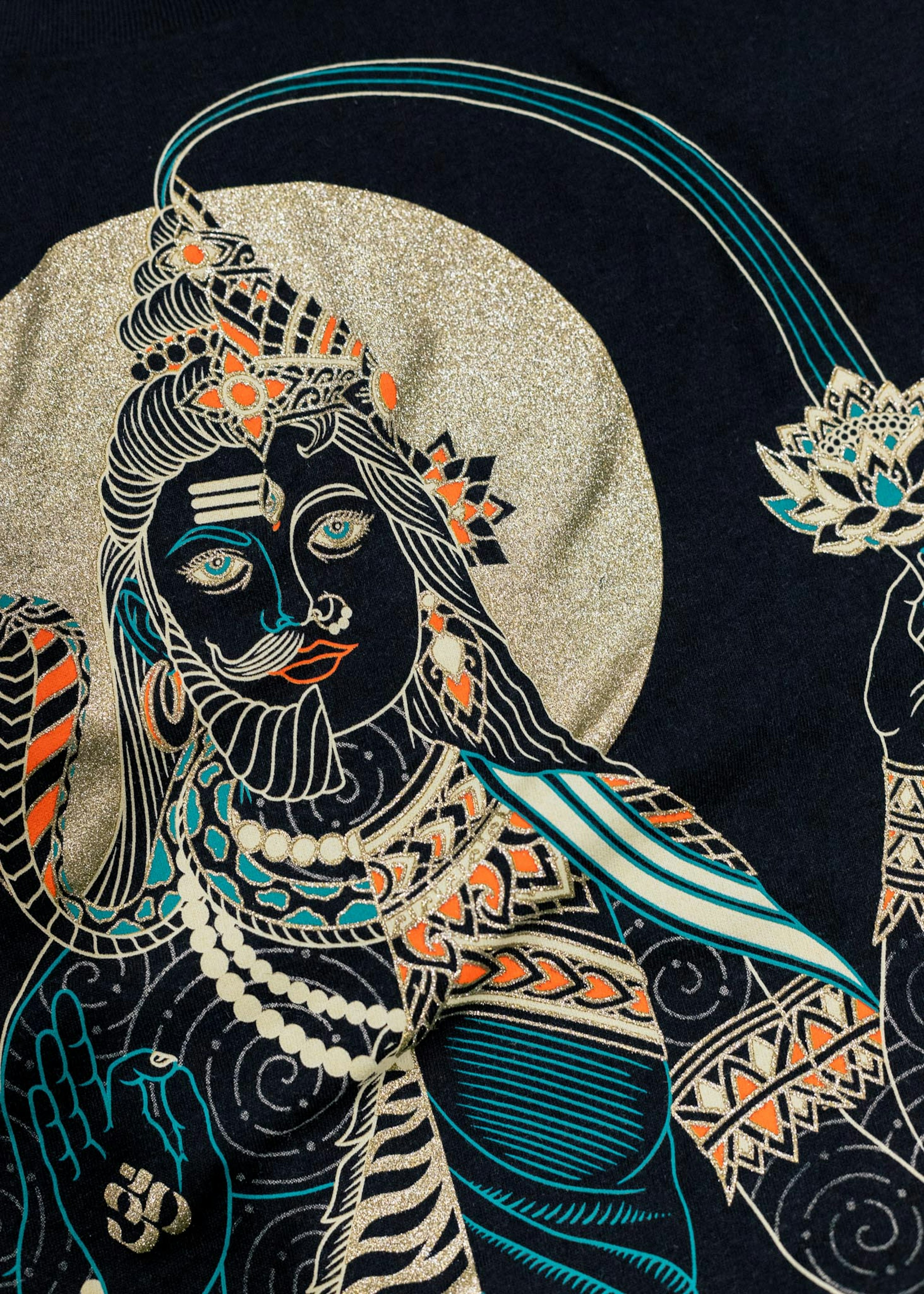 A close-up of a shirt with a colorful design, containing a gold metallic ink