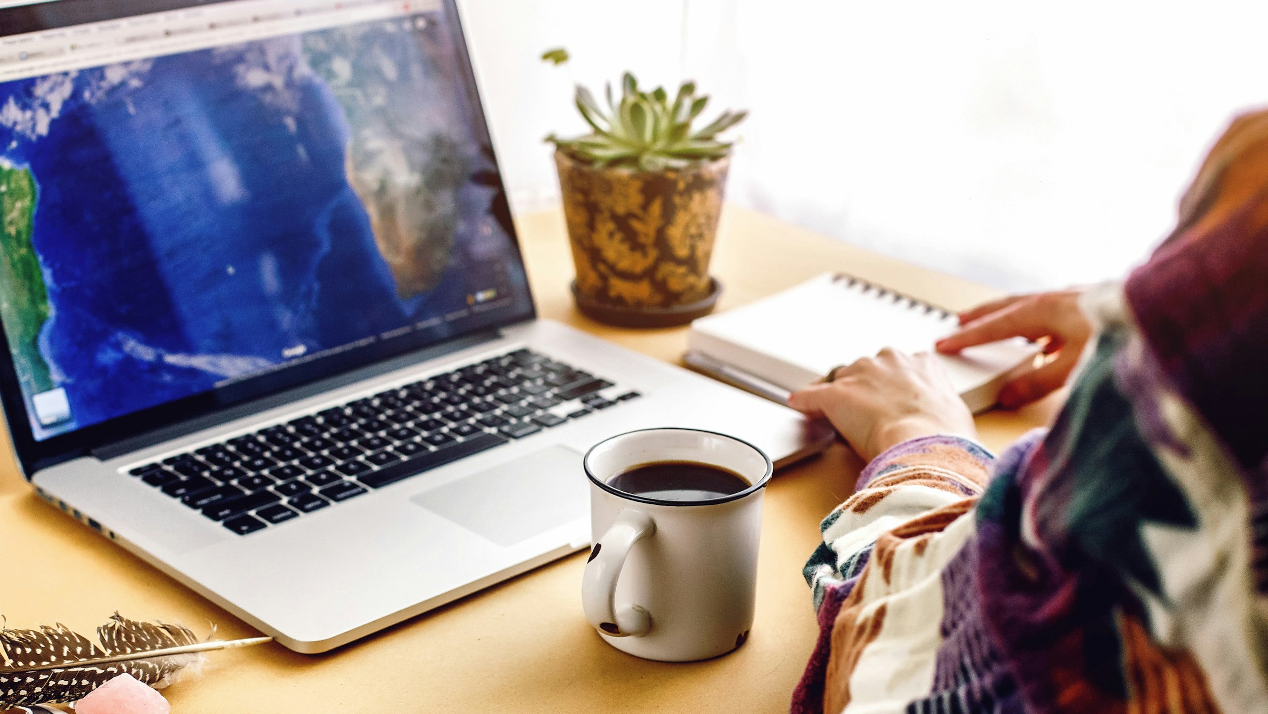 some sitting at a table with a laptop and coffee