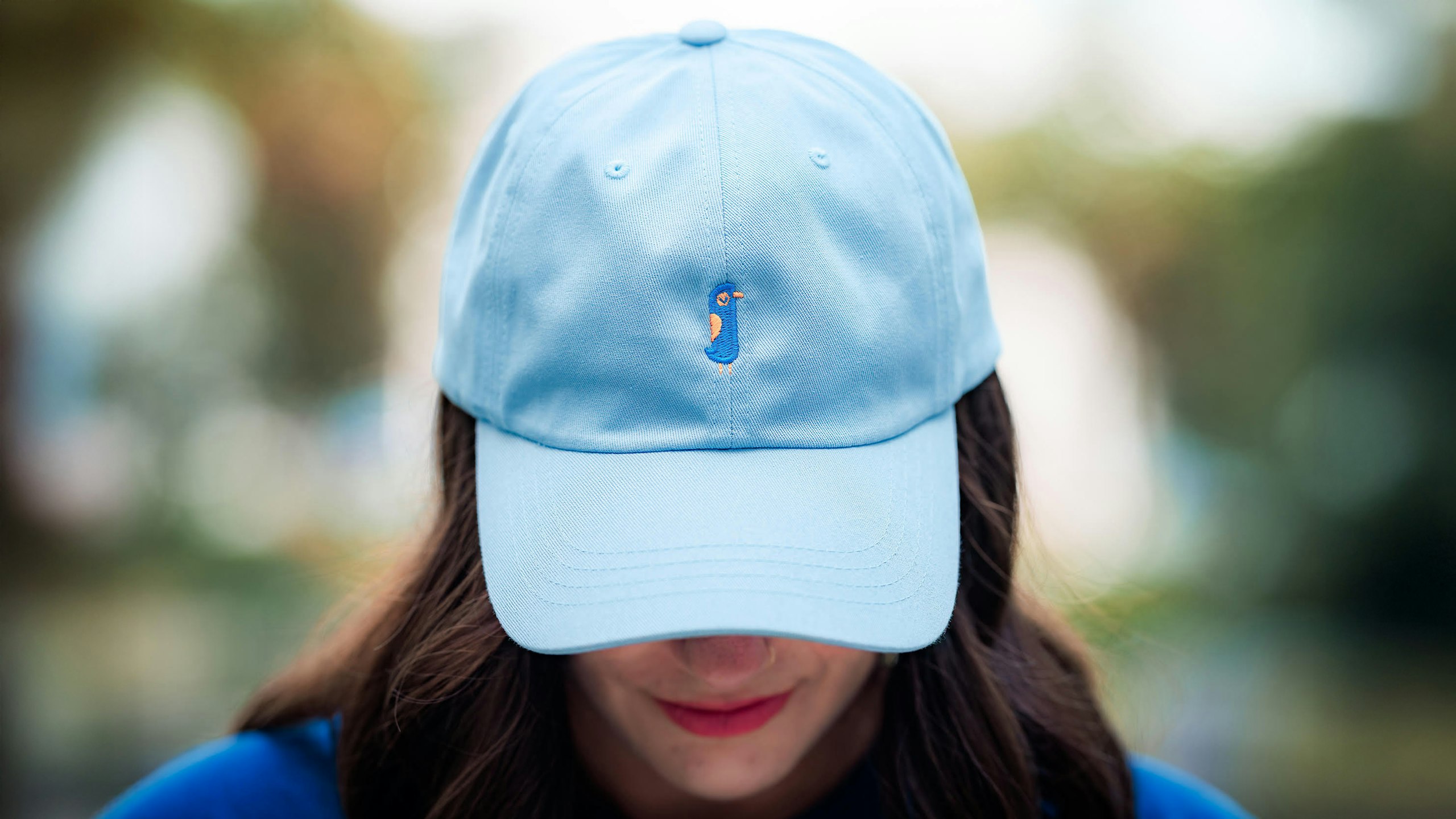 Someone is wearing a light blue dad hat with the Orlando Informer logo