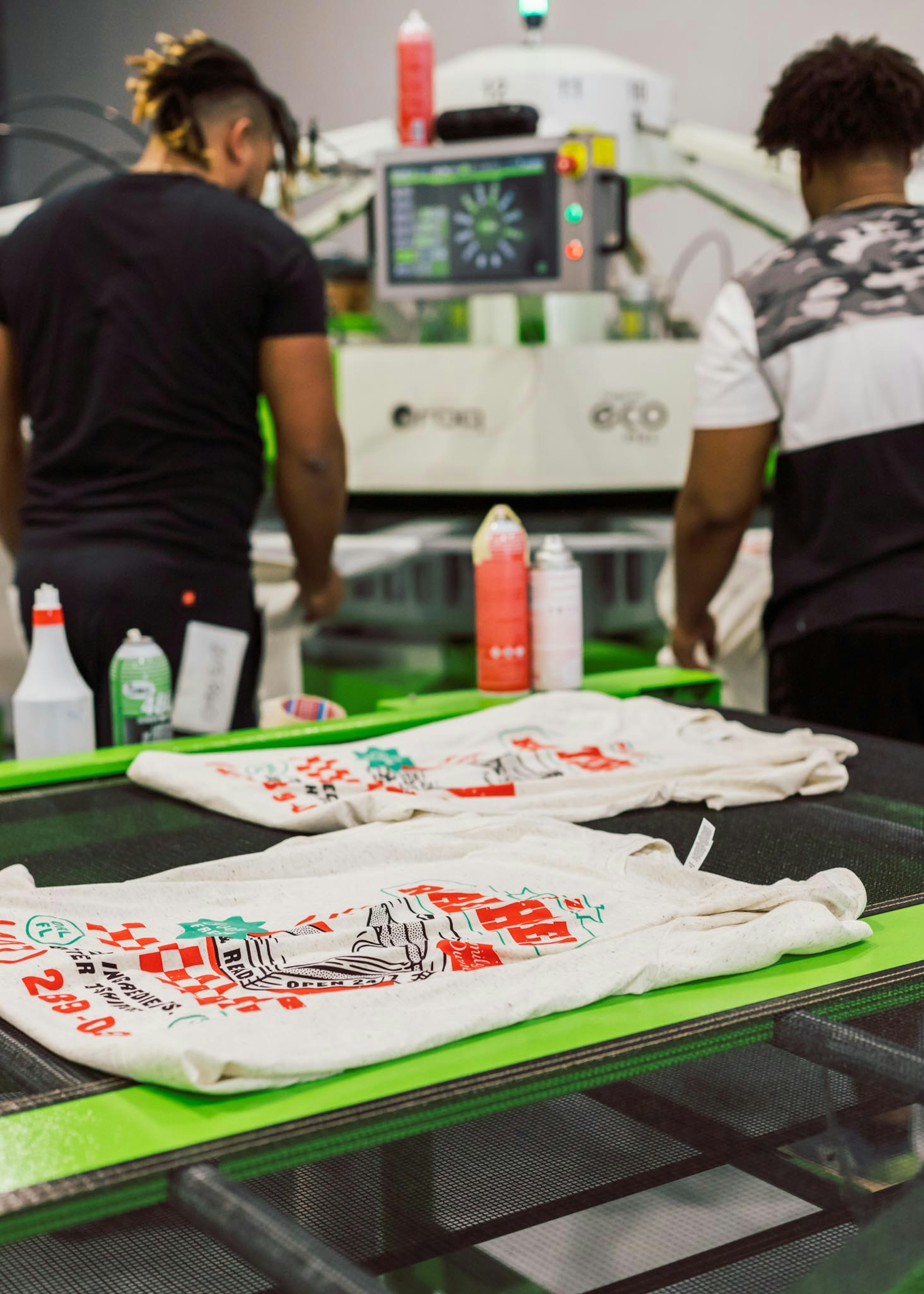 white shirts with a pizza design laying on the t-shirt dryer
