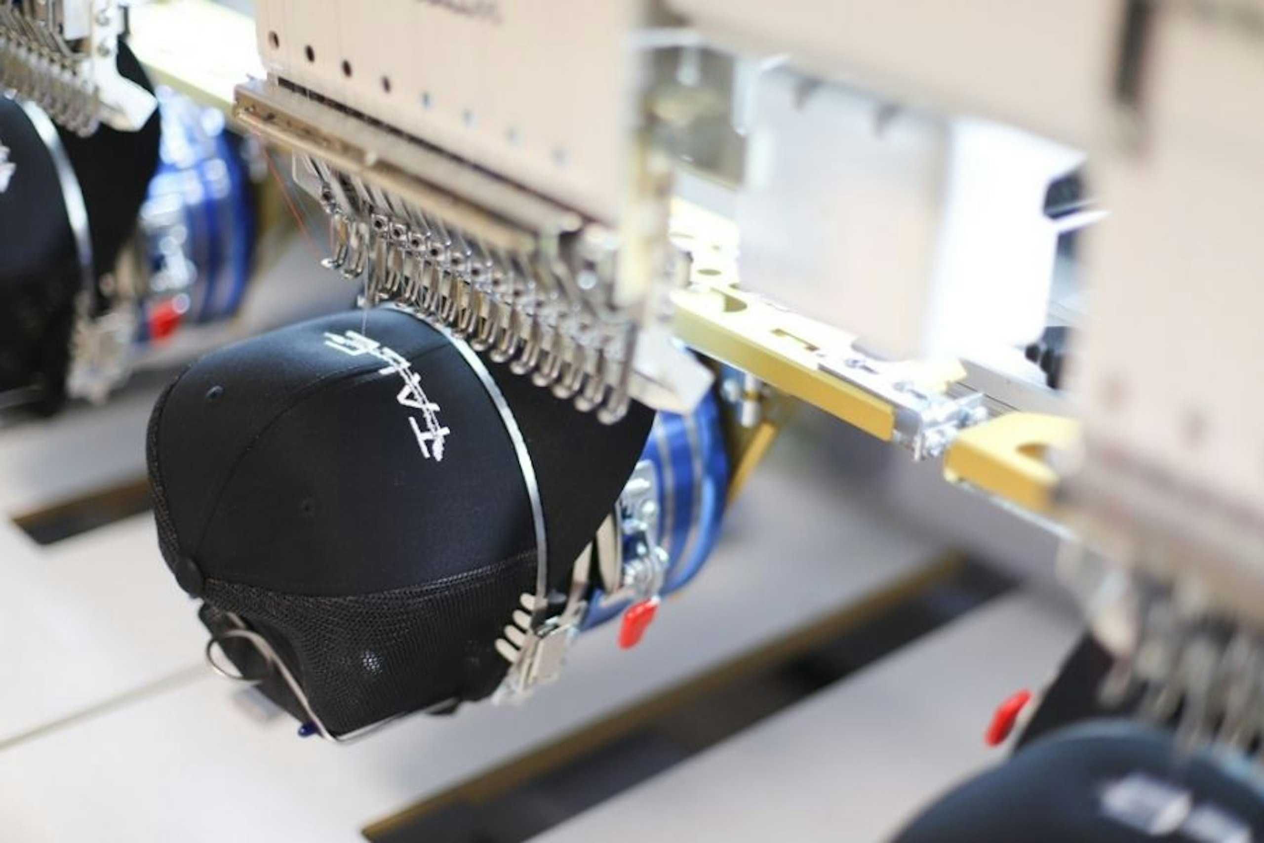 a black hat being embroidered by the embroidery machine