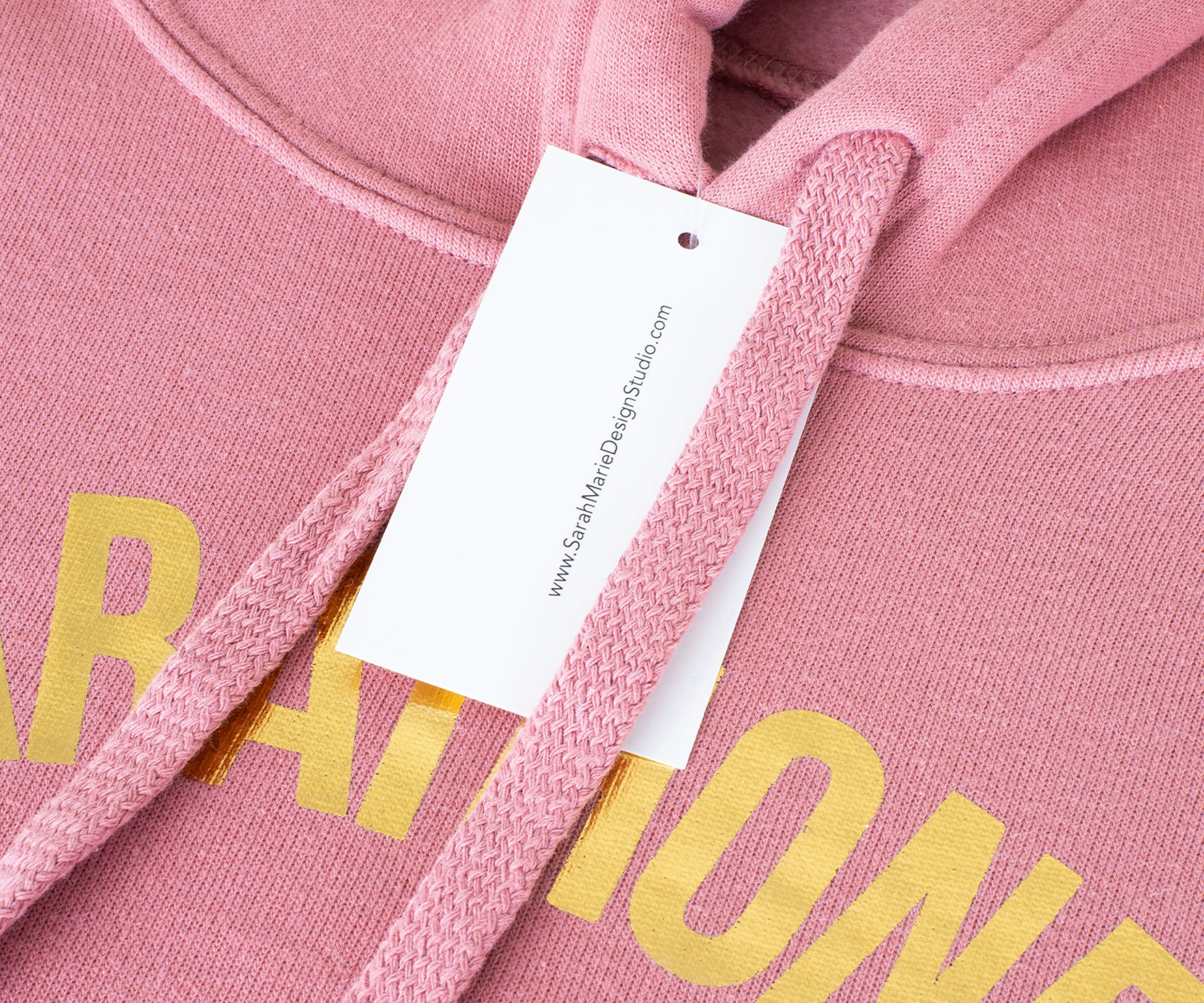 white hang tag on a pink hoodie