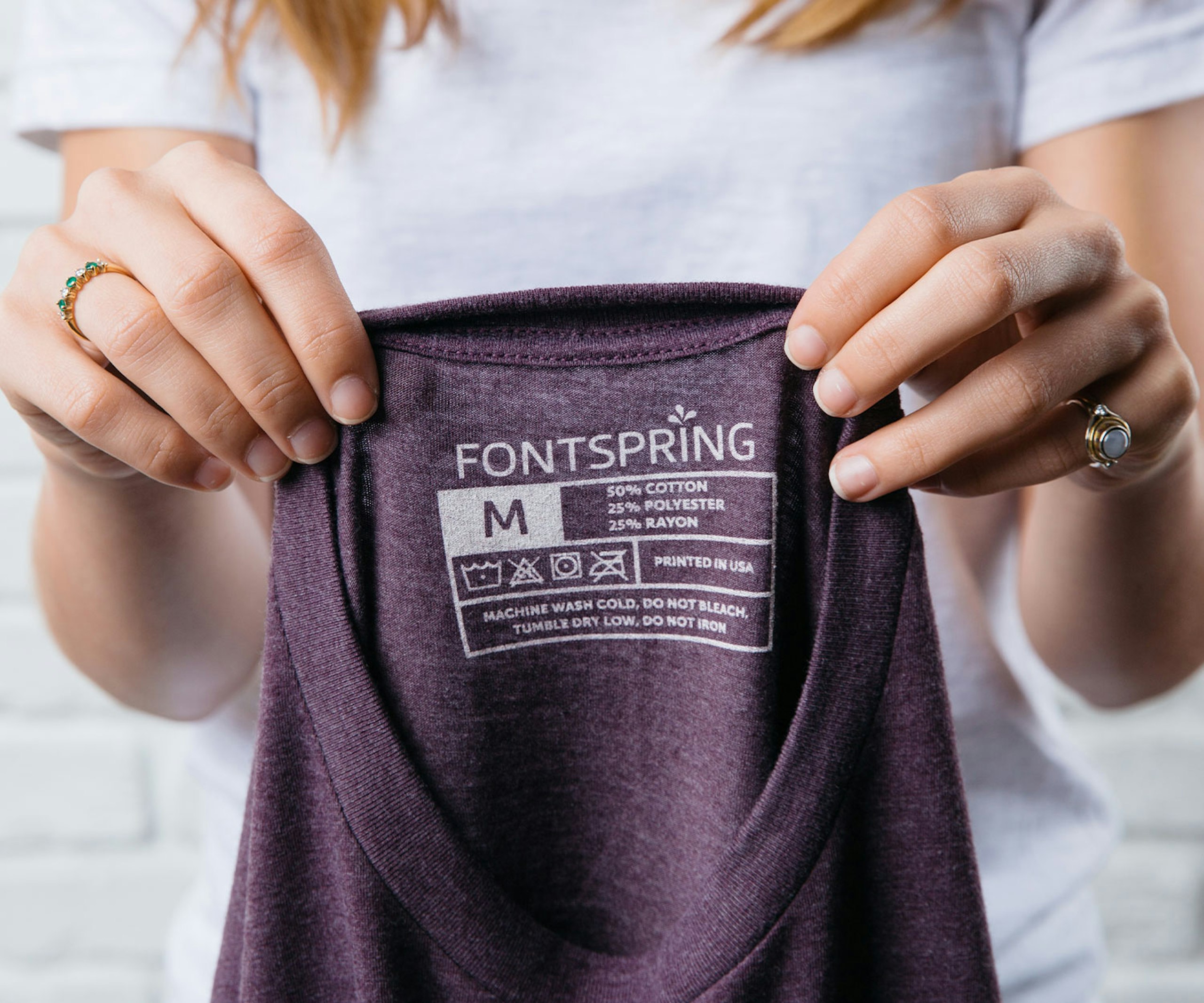 women holding a t-shirt showing the printed tag