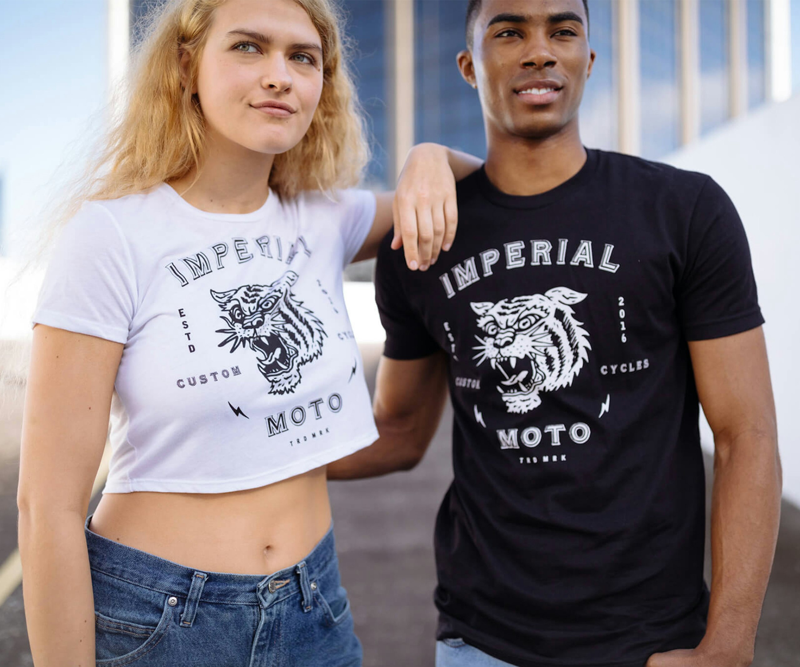women wearing a cropped white t-shirt and a man wearing a black t-shirt