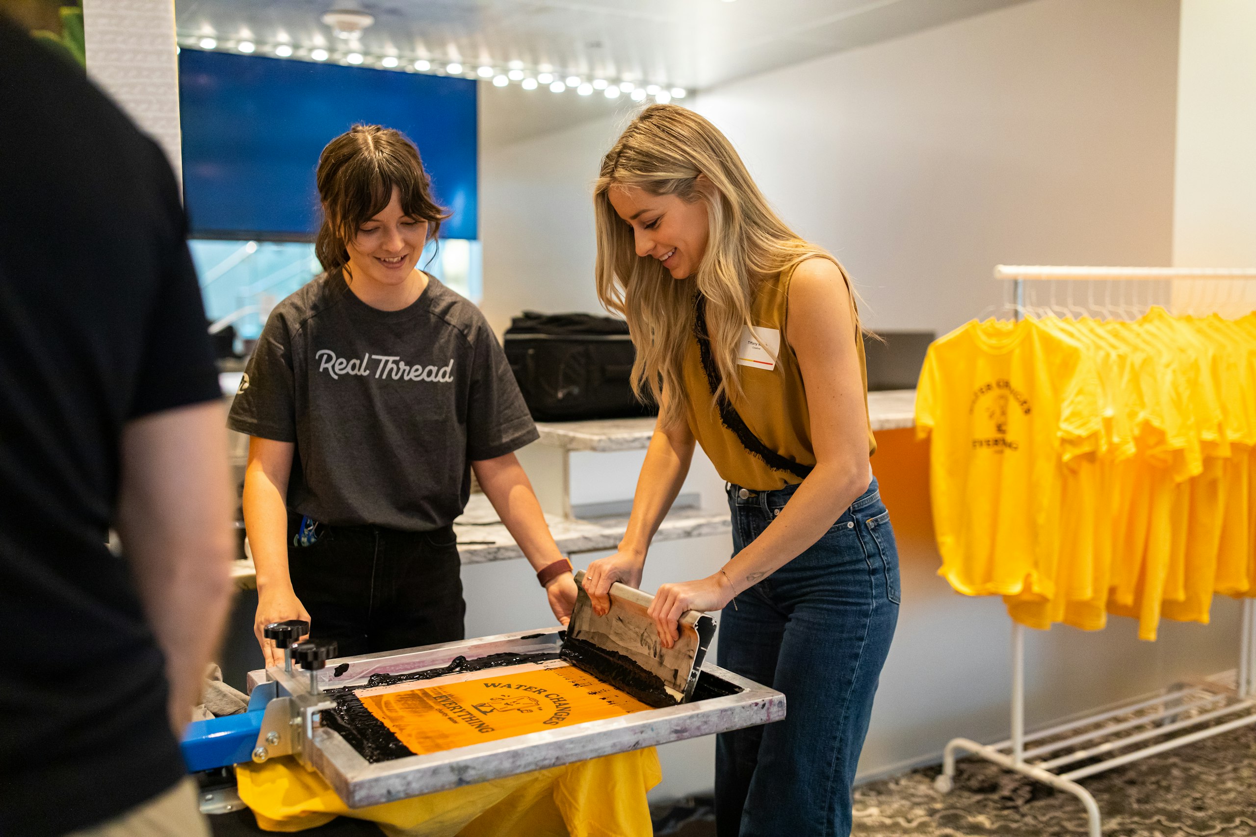 Two women live screen-printing at an event