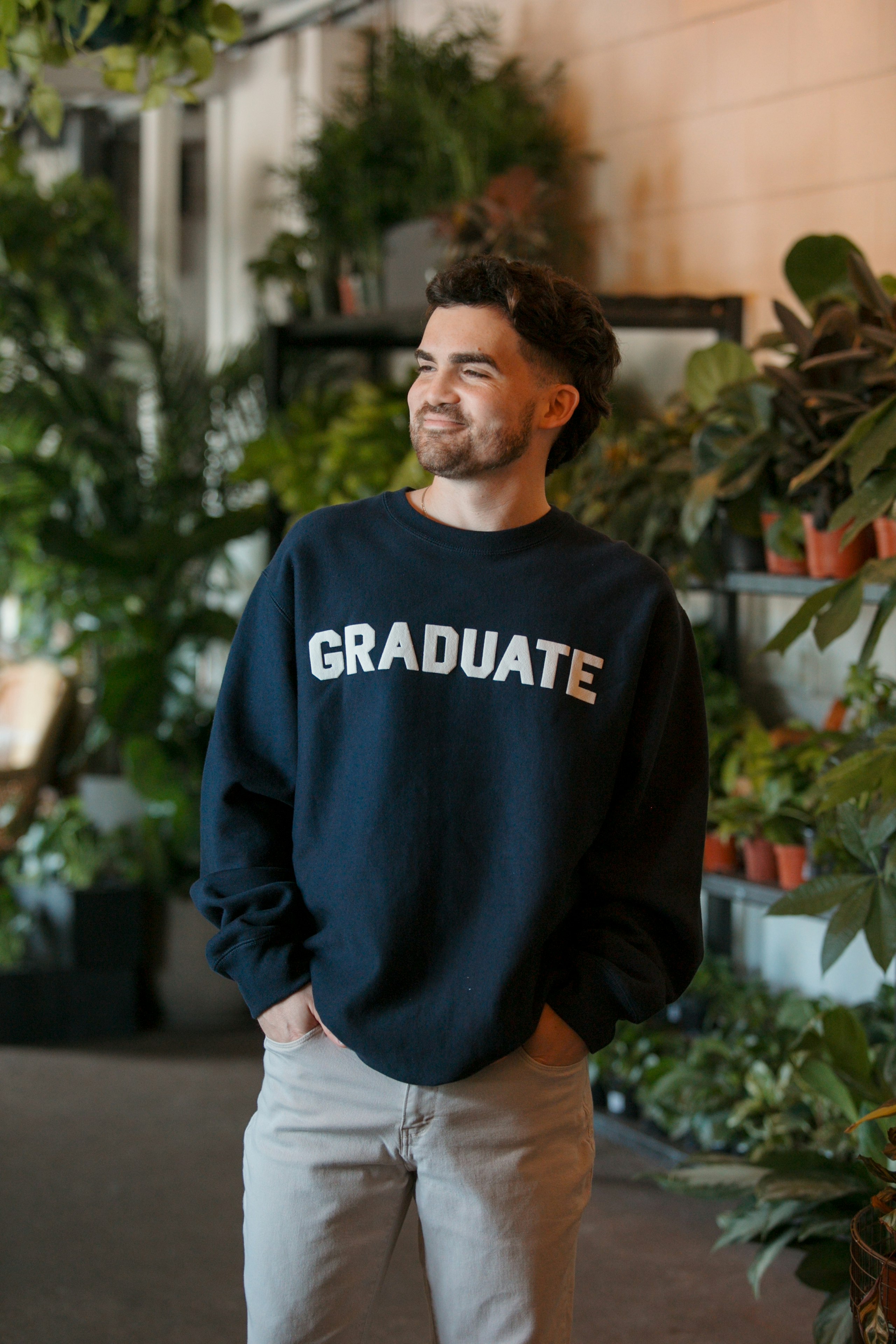 man wearing a dark navy hoodie with the word graduate printed in white puff print