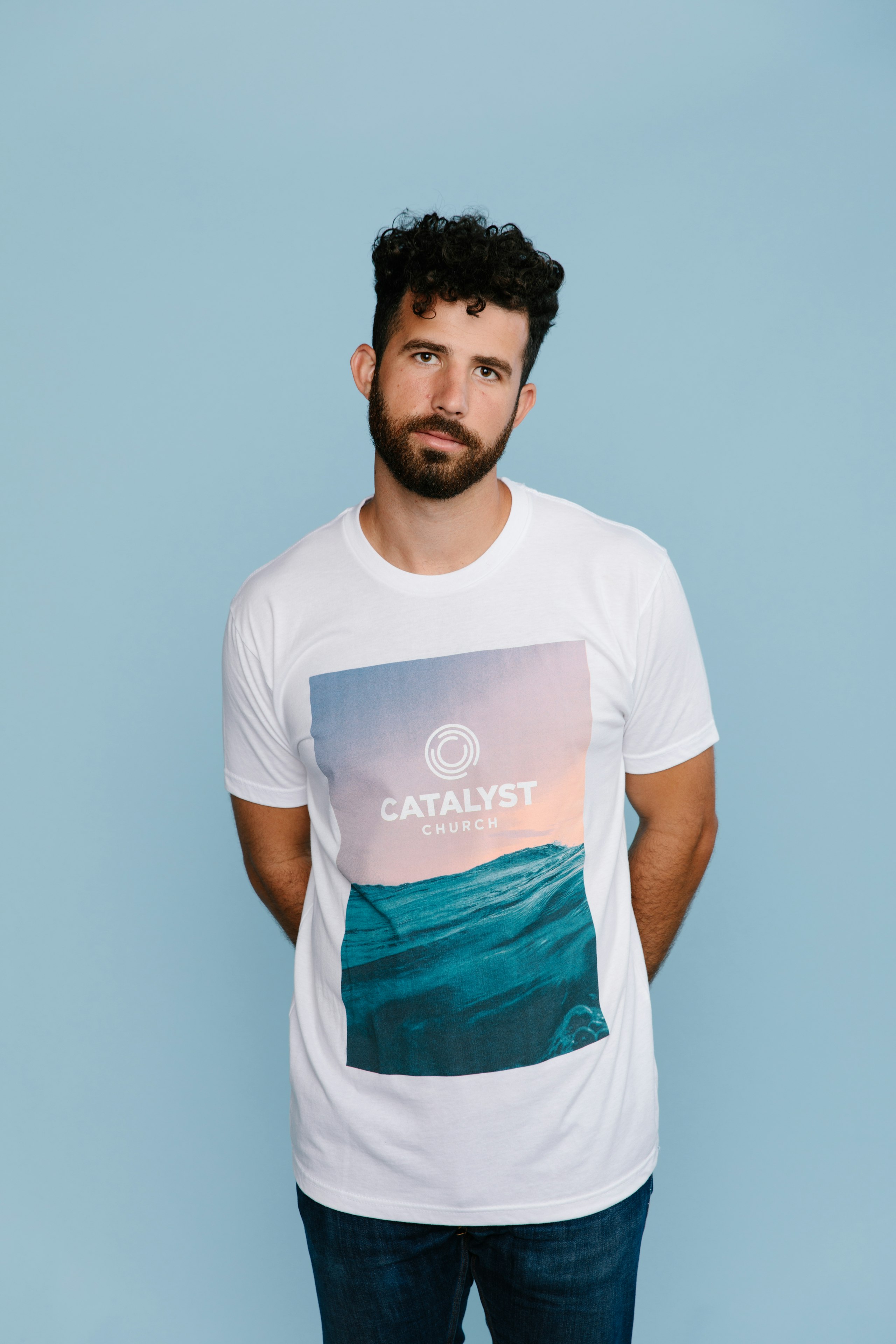 man wearing a white shirt with an image of an ocean printed on it