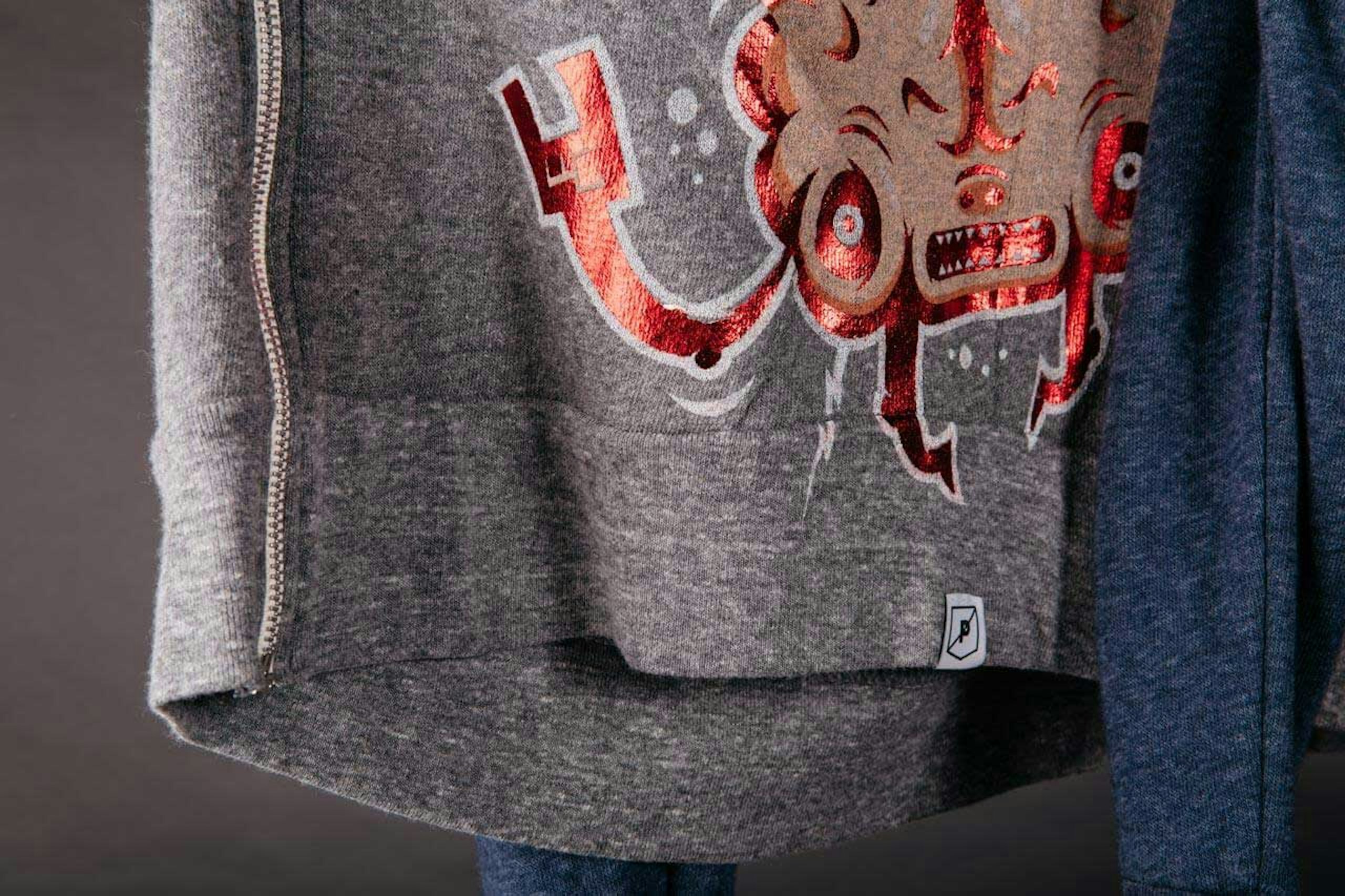 zip up jacket with red foil print on it