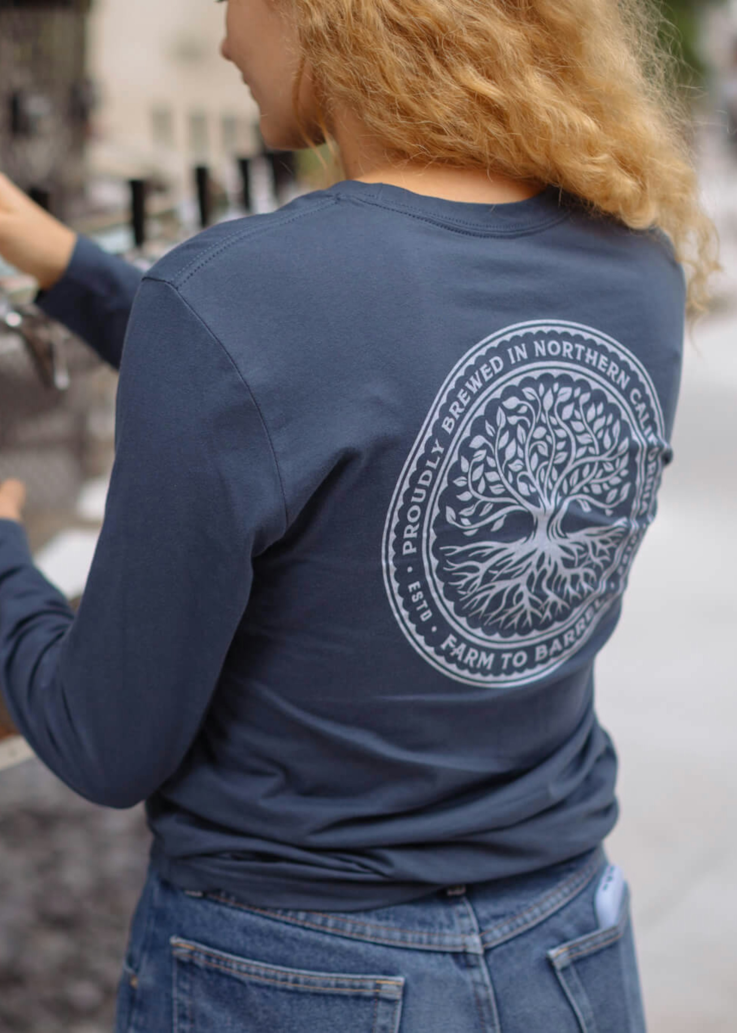 woman pouring beer in a navy long-sleeve tee