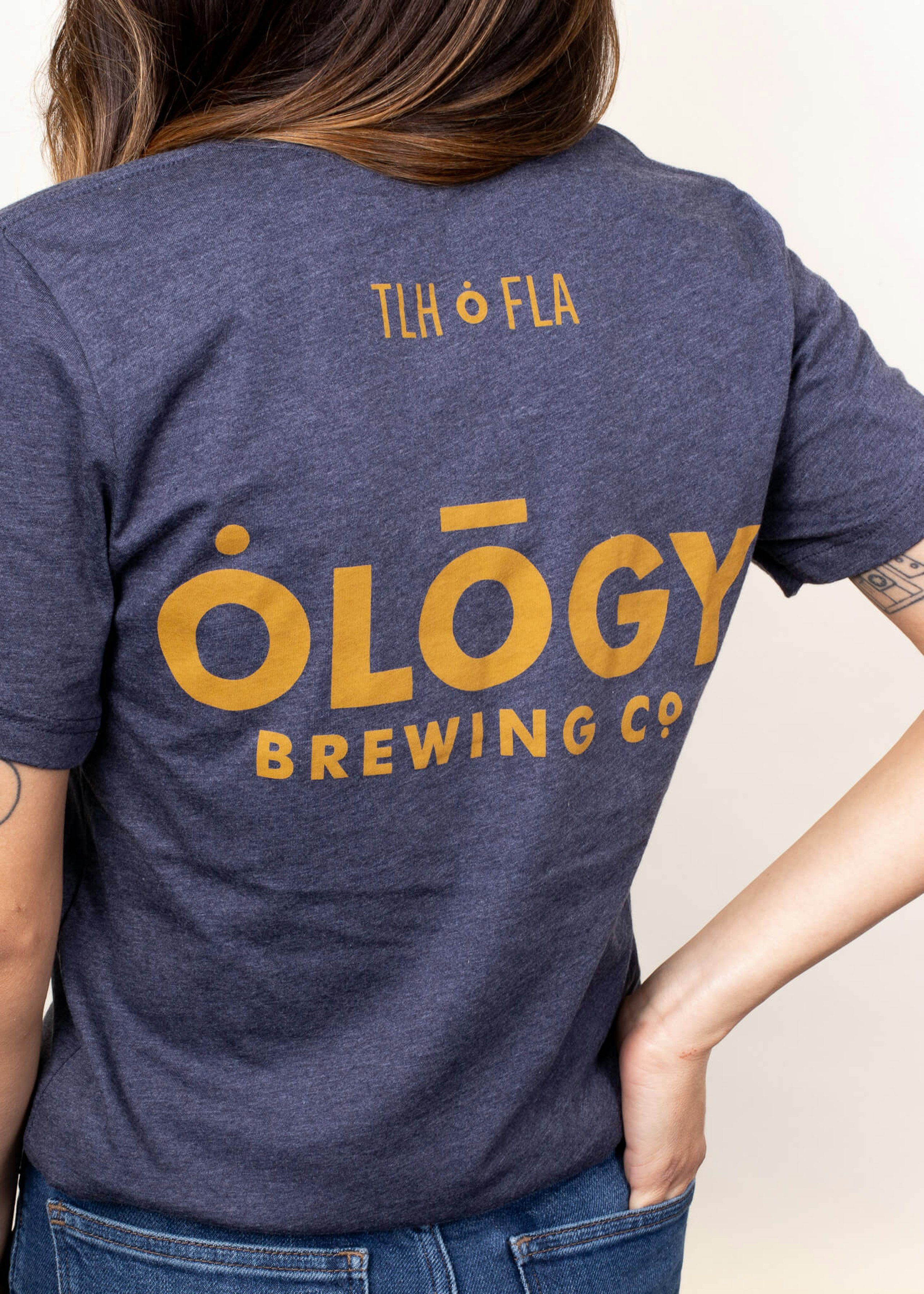 woman wearing a blue tee with gold letters