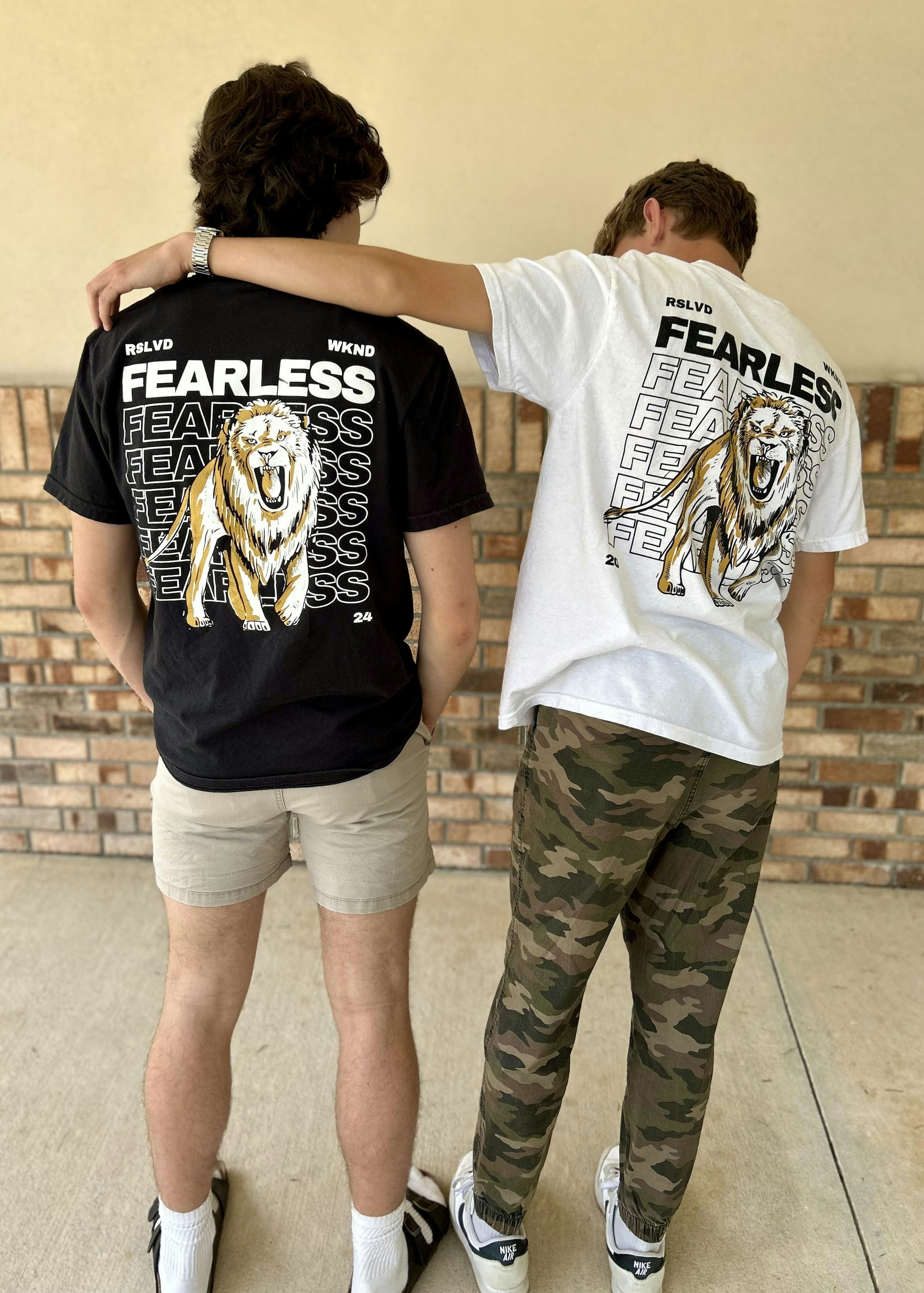 two teenage men wearing student ministry t-shirts, one black t-shirt and the other white t-shirt
