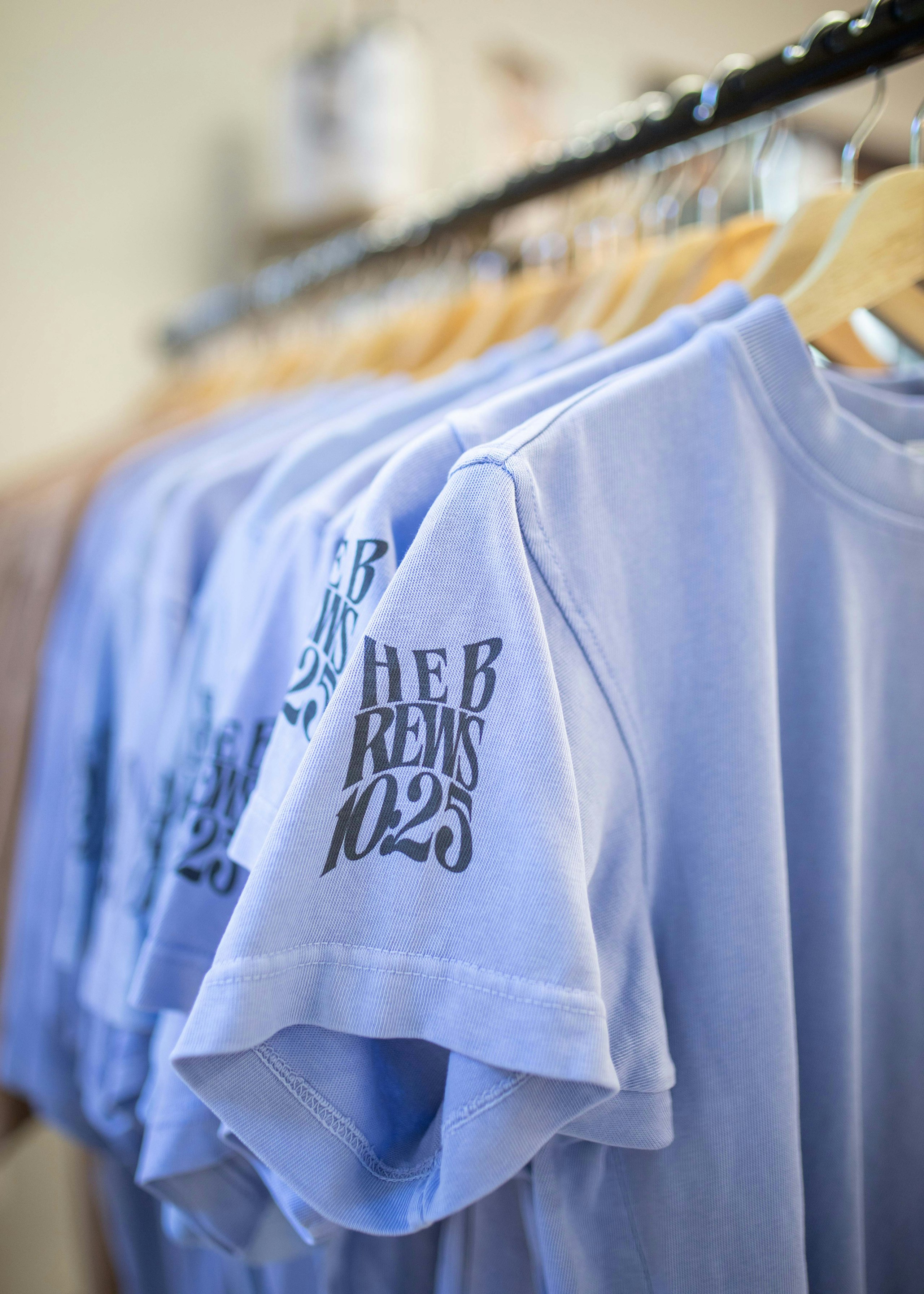 purple and tan t-shirts hanging on a rack
